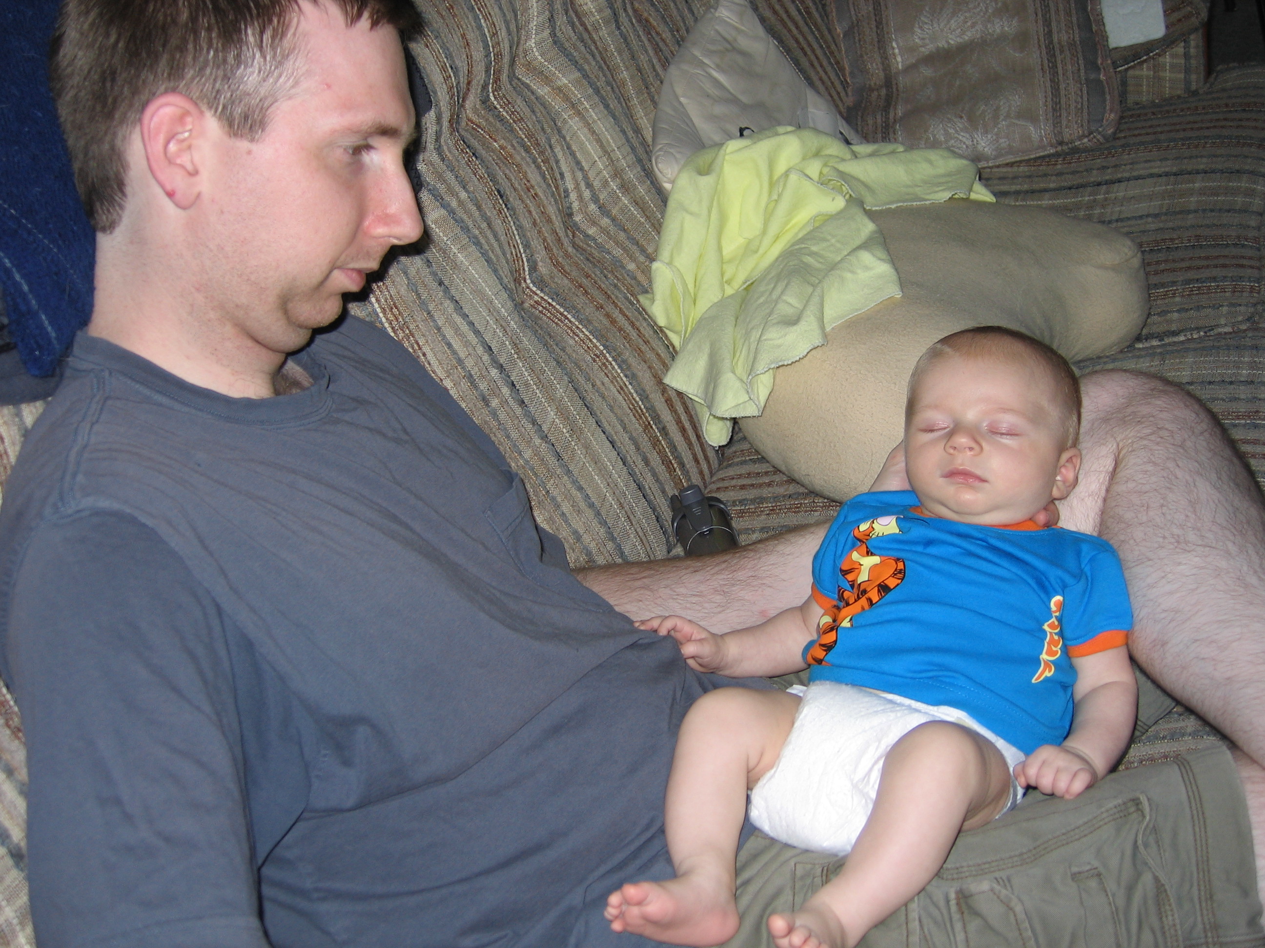 Aidan sleeps peacefully on his Daddy's lap.